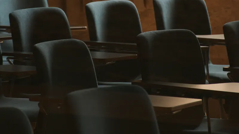 Une salle de cours vide avec des tables et des chaises